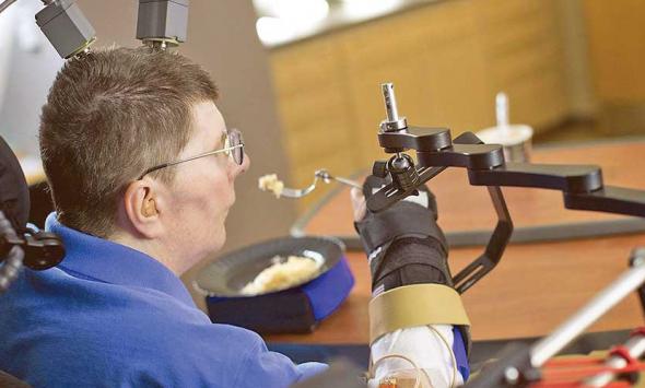 Paralysed man is able to feed himself for the first time in 30 years thanks to robotic arms