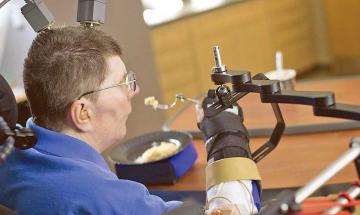 Paralysed man is able to feed himself for the first time in 30 years thanks to robotic arms