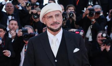 John Travolta reveals why he wore viral berets throughout Cannes debut